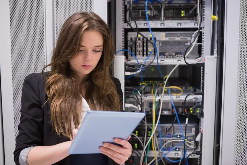 Woman using tablet pc in front of servers in data center-3 (1)
